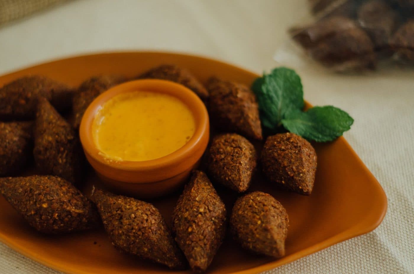 Mini kibes com molho e folhas de hortelã