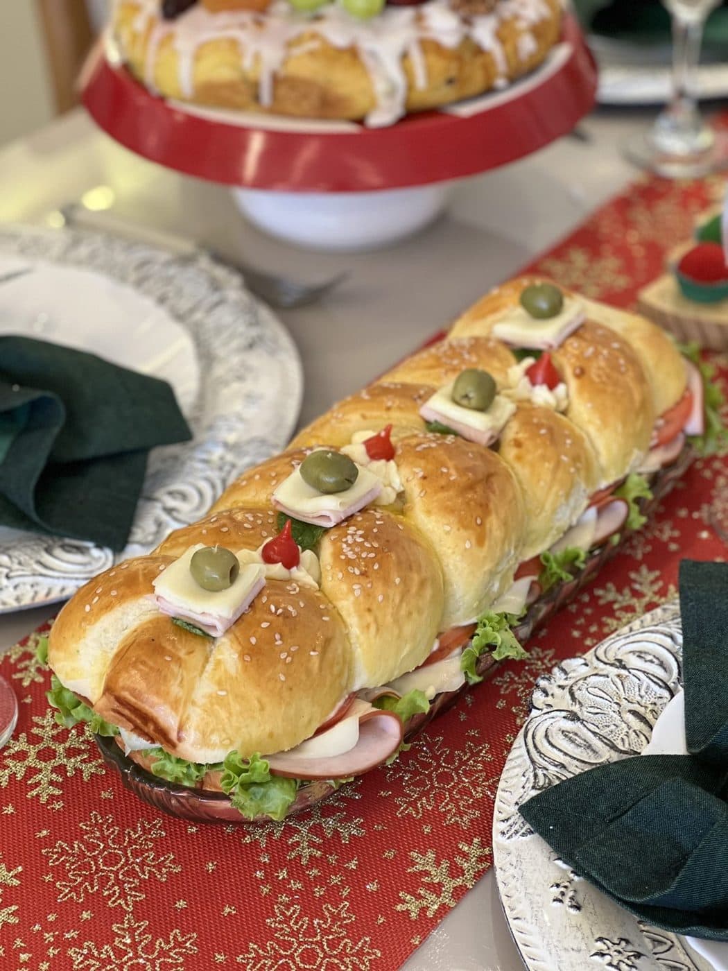 Pão metro trançado, recheado e decorado, numa mesa de Natal